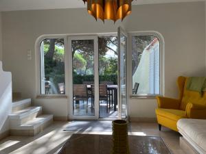 a living room with a table and a yellow couch at Private Villa in Quinta da Marinha with golf view! in Cascais