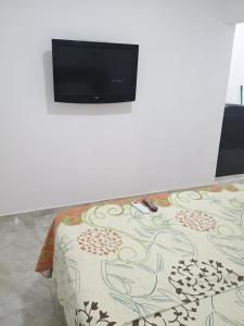 einen Flachbild-TV auf einer Wand über einer Couch in der Unterkunft Alojamiento valerie in Neiva