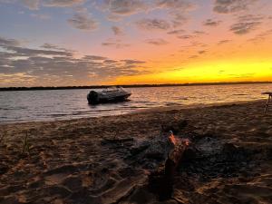 ein Boot am Strand bei Sonnenuntergang in der Unterkunft Rio Tranquilo in Concepción del Uruguay