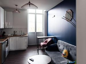 uma sala de estar com um sofá e uma cozinha em Belle Isle em Châteauroux