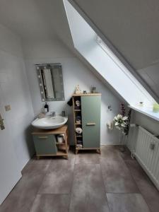 uma casa de banho com um lavatório e um espelho em Watt´ne Bude in Büsum em Büsum