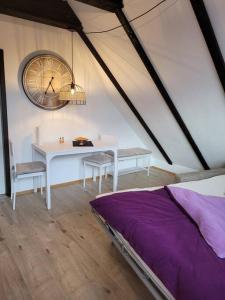 Watt´ne Bude in Büsum في بوسوم: غرفة بطاولة وساعة على الحائط
