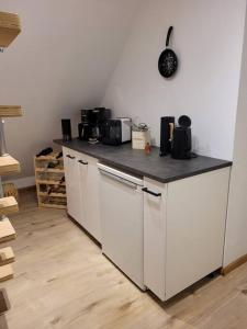 a kitchen with white cabinets and a black counter top at Watt´ne Bude in Büsum in Büsum