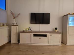 a living room with a tv on the wall at Watt ne Bude in Büsum - Krabbeliebe Büsum in Büsum