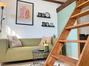 sala de estar con sofá verde y escalera de madera en Holiday home Sukha en Grabrovnik