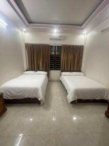 ハザンにあるHolly's Hostel Ha Giang B&Bのベッド2台と窓のある寝室 +5枚の写真