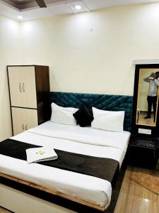 - une chambre avec deux lits et une photo d'une femme dans l'établissement HOTEL RAJ - Near RAILWAY STATION , HARIDWAR, à Haridwar