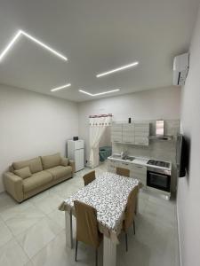 Ercolano Beautiful house في إيركولانو: مطبخ وغرفة معيشة مع طاولة وأريكة
