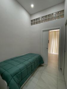 een slaapkamer met een groen bed in de hoek bij Ercolano Beautiful house in Ercolano