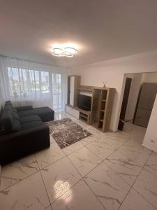 ein Wohnzimmer mit einem Sofa und einem TV in der Unterkunft Apartament 2 camere Sector 1 in Bukarest