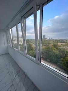 an empty room with four windows in a building at Apartament 2 camere Sector 1 in Bucharest