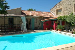 a swimming pool in front of a house at La Picholine chambre Provence in Courry