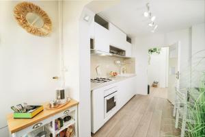 a kitchen with white cabinets and a counter top at High quality family - Calliope apartment in Timişoara