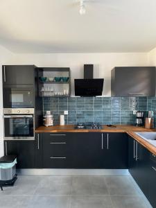 a kitchen with black cabinets and wooden counter tops at Villa Primo 1 in Le Lambert