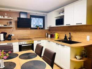 a kitchen with white cabinets and a table with chairs at Charming Apartment with Mountain View in Altmünster