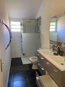 a bathroom with a toilet and a sink at Le Temps des prunes - 4 personnes in Cilaos
