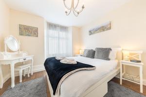 Enjoy relaxing family breaks in this central Ambleside apartment with parking في آمبيلسايد: غرفة نوم بسرير ومكتب ومرآة