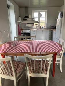 uma cozinha com uma mesa e cadeiras vermelhas e brancas em Eternellgården em Kivik