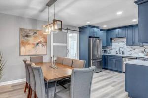 cocina con mesa de comedor y armarios azules en Gorgeous Pool Home - 5 Min from San Marco, en Jacksonville