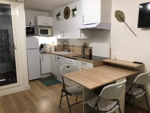 - une cuisine avec une table en bois et des placards blancs dans l'établissement Studio cabine en bord de mer, à La Grande-Motte, à La Grande Motte