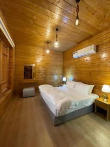 a bedroom with a bed in a wooden wall at اكواخ وشاليهات لوزان الريفية in Dahaban