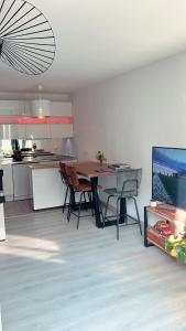 a kitchen and dining room with a table and chairs at Appartement avec Jardin - La Plaine Saint Denis in Saint-Denis
