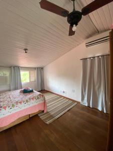 1 dormitorio con 1 cama y ventilador de techo en No mar, condomínio pé na areia, en Florianópolis