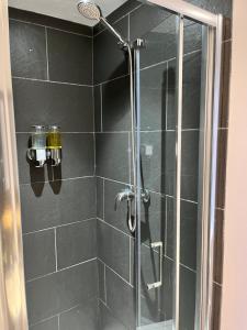 a bathroom with a shower with a glass door at The Railway Hotel in Haydon Bridge
