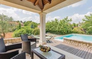 a patio with a table and chairs and a swimming pool at Villa & Ferienwohnung Rosa in Stari Pazin