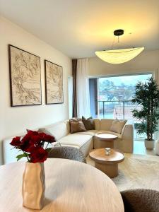 uma sala de estar com um sofá e uma mesa com rosas em Nydelig perle rett ved fjorden em Sandnes