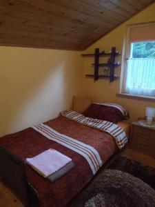 1 dormitorio con 2 camas y ventana. en Agroturystyka u Psotki, en Kużmina