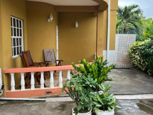 a porch of a house with two chairs and plants at Estuary Apartments 2B in Dunfermline