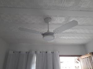 a ceiling fan on a room with a window at Penedo - Quitinete para temporada in Itatiaia