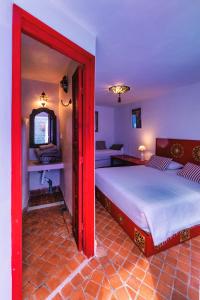a bedroom with two beds and a red doorway at Dar Zambra in Chefchaouen