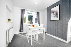 a white dining room with a white table and chairs at 3 Bedroom House - Parking - Garden - Great Barr - Netflix - Top Rated -121J in Birmingham