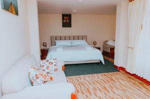 - une chambre avec un lit et deux canapés blancs dans l'établissement AVANI HOSPEDAJE, à Lligua