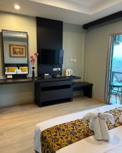 Aloha Residence في شاطئ كاتا: غرفه فندقيه سرير وتلفزيون