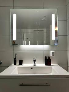 a bathroom with a white sink and a mirror at Nydelig perle rett ved fjorden in Sandnes