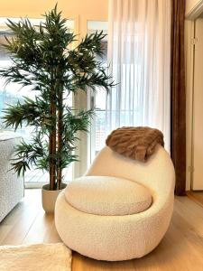 a circular ottoman in a living room with a plant at Nydelig perle rett ved fjorden in Sandnes