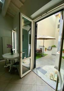 uma porta aberta para um pátio com uma mesa e um guarda-chuva em La casetta in fondo all'orto em Viareggio