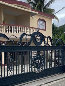 a black iron fence in front of a house at Y Beautiful and comfortable in Moca