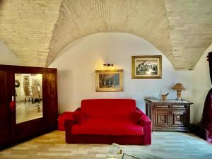 a living room with a red couch and a table at Spello Vacanze Dante's House piano terra in Spello