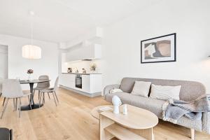 ein Wohnzimmer mit einem Sofa und einem Tisch in der Unterkunft Spacious waterfront apartment with marina and sea view in Arhus