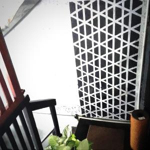 a plant sitting next to a chair next to a wall at Yak City Apartments in Kandy