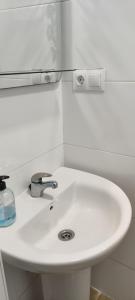 lavabo blanco con espejo encima en Apartamento centro de Malaga, en Málaga