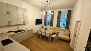 a kitchen and living room with a table and a couch at Apartmán Maxmilián**** s parkováním zdarma in Karlovy Vary