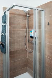 La salle de bains est pourvue d'une douche avec une porte en verre. dans l'établissement Moderne 3-Zimmer-Wohnung in Top-Lage, à Karlsruhe