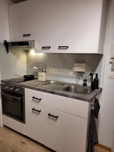 uma cozinha branca com um lavatório e um fogão em Watt´ne Bude in Büsum em Büsum