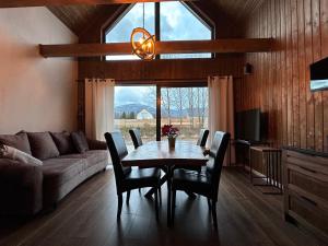 a living room with a table and chairs and a couch at REST ZONE - mountain holiday chalets in Ściegny