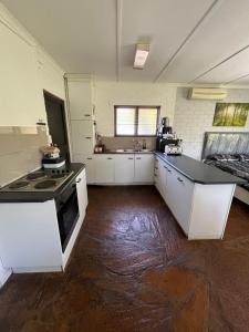 a kitchen with white cabinets and a stove at The Treehouse in Amanzimtoti